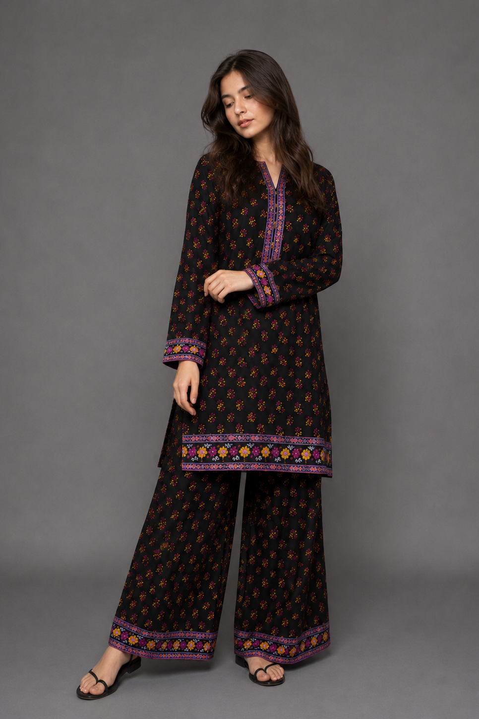 Woman wearing a black patterned outfit on a gray background