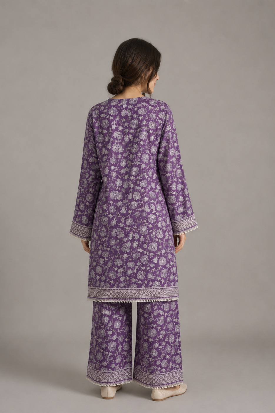 Person wearing a purple floral outfit with a plain background