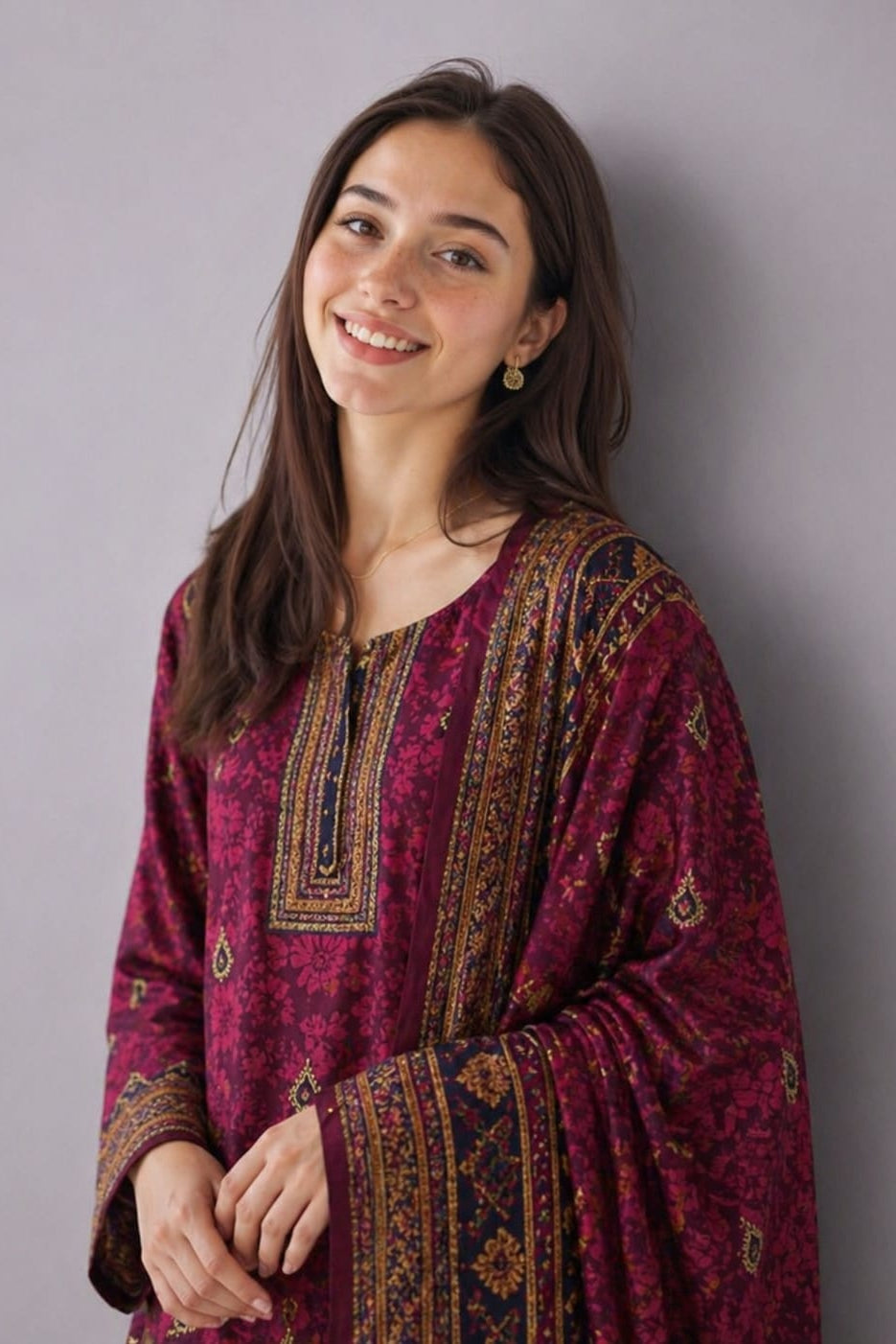 Woman wearing a patterned maroon kurta against a plain background