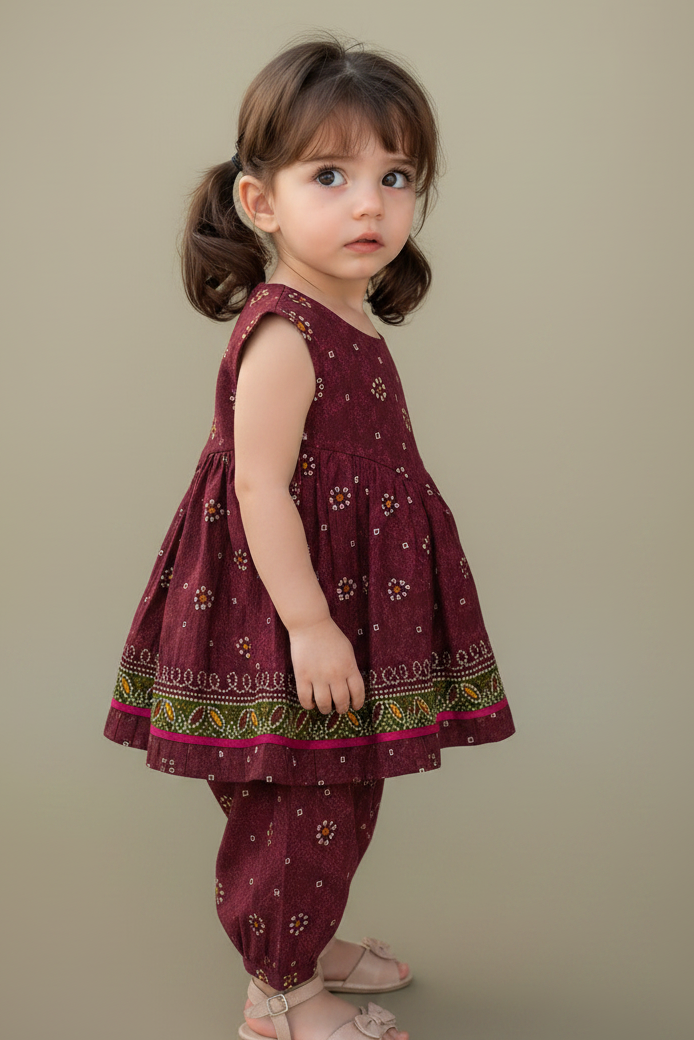 Young girl wearing a maroon traditional outfit with floral patterns on a beige background