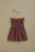 Floral dress on a hanger against a beige wall