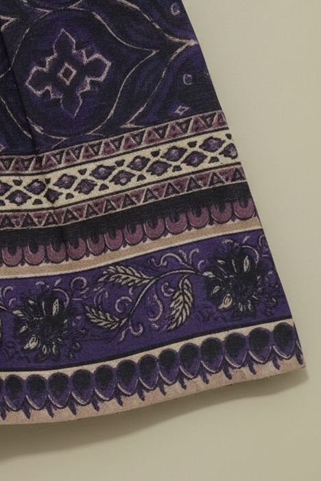 Purple fabric with intricate patterns on a beige background